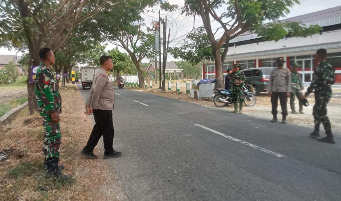 Personel Polsek Kedungadem turun langsung mengamankan proses pembongkaran bangunan lama yang akan disulap menjadi kawasan pujasera (rest area) lengkap dengan mushala dan toilet umum, Sabtu (18/7/2026).