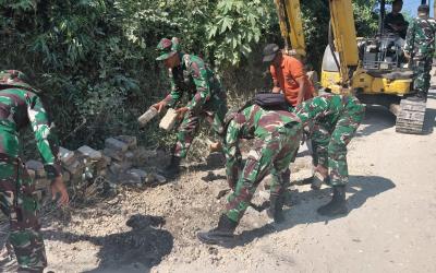 Personel Satgas TMMD ke-129 Kodim 0813 Bojonegoro bersama warga mulai membongkar paving lama sebagai langkah awal pembangunan jalan cor beton yang akan meningkatkan akses transportasi di wilayah tersebut.
