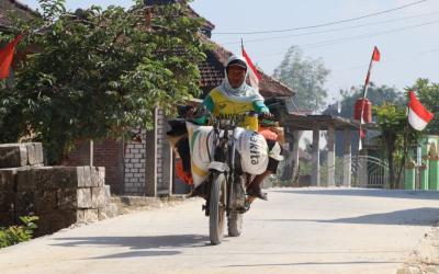 Foto: Seorang warga melintas di atas jalan cor beton hasil pembangunan TMMD ke-129 Kodim 0813/Bojonegoro di Dusun Kedungpandan, Desa Kesongo, Kecamatan Kedungadem, Rabu (5/8/2026). Infrastruktur baru ini mempermudah akses masyarakat sekaligus mendukung aktivitas ekonomi, pendidikan, dan pelayanan kesehatan. Foto: Deni Aripandi/Sumber TMMD Bojonegoro.