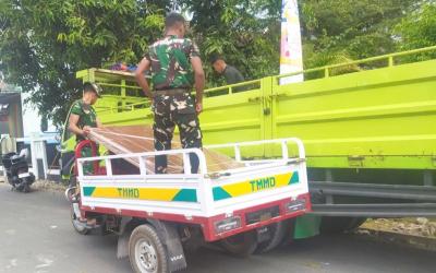 Di Desa Kesongo, Kecamatan Kedungadem, Kabupaten Bojonegoro, Sabtu (1/8/2026), personel Satgas TMMD memanfaatkan kendaraan roda tiga untuk mengangkut material bangunan menuju rumah-rumah penerima manfaat yang berada di gang sempit.