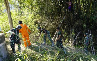 Melalui aksi gotong royong, personel Satgas TMMD bersama masyarakat melaksanakan kerja bakti membersihkan bantaran Sungai Kesongo di sekitar Jembatan Brang Etan, Desa Kesongo, Kecamatan Kedungadem, Minggu (26/7/2026).