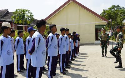 Anggota Satgas TMMD ke-129 Kodim 0813/Bojonegoro melatih Peraturan Baris Berbaris (PBB) kepada siswa SMP Negeri Satu Atap Kesongo, Desa Kesongo, Kecamatan Kedungadem, Kabupaten Bojonegoro.