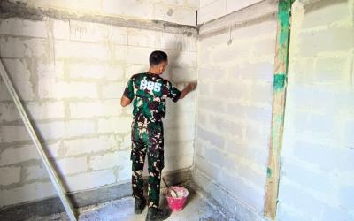 Dinding bata ringan yang sebelumnya tampak sederhana kini mulai terlihat lebih rapi setelah mendapat sentuhan tangan para prajurit Satgas TNI Manunggal Membangun Desa (TMMD) ke-129 Kodim 0813 Bojonegoro.