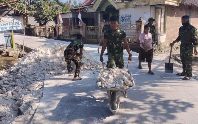 Satgas TMMD ke-129 Kodim 0813/Bojonegoro bersama warga mengangkut dan meratakan material pedel untuk memperkuat bahu jalan cor di Dusun Mundu, Desa Kesongo, Kecamatan Kedungadem, Kabupaten Bojonegoro.