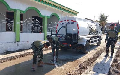 Anggota Satgas TMMD ke-129 Kodim 0813 Bojonegoro melakukan penyiraman atau curing jalan cor di Dusun Krebet, Desa Kesongo, Kecamatan Kedungadem, Kabupaten Bojonegoro, Minggu (09/08/2026). Foto: Deni Ari Pandi/Sumber: TMMD Bojonegoro.