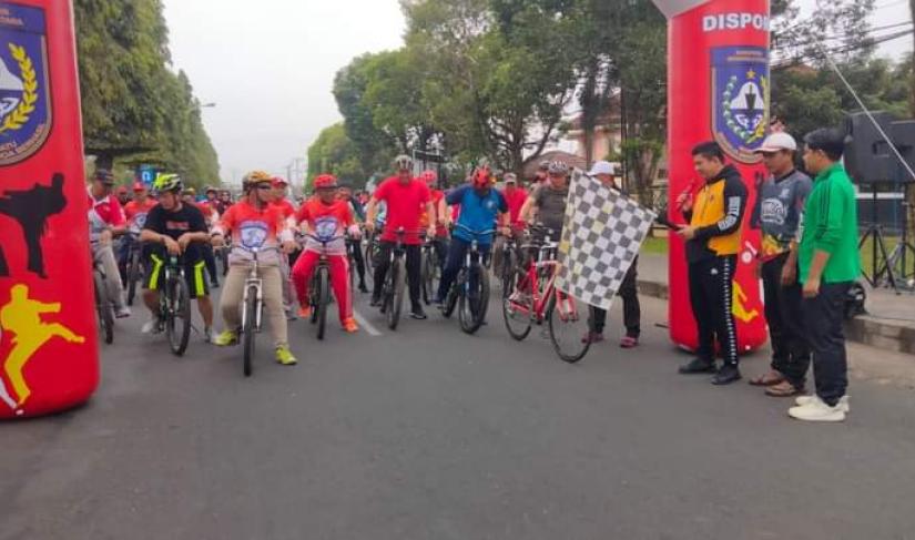 Wabup BU Arie Septia Adinata SE M.Ap.mengangkat bendera star tanda sepeda santai akan di mulai 