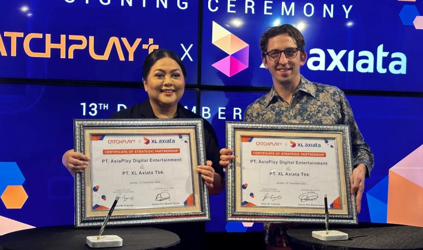 Country Manager CATCHPLAY+ Indonesia, Dhini W Prayogo (kiri) bersama dengan Chief Marketing Officer XL Axiata, Alfons Bosch Sansa (kanan) melakukan penandatanganan kerja sama antara XL Axiata dengan CATCHPLAY+ di Jakarta, Rabu (13/12).