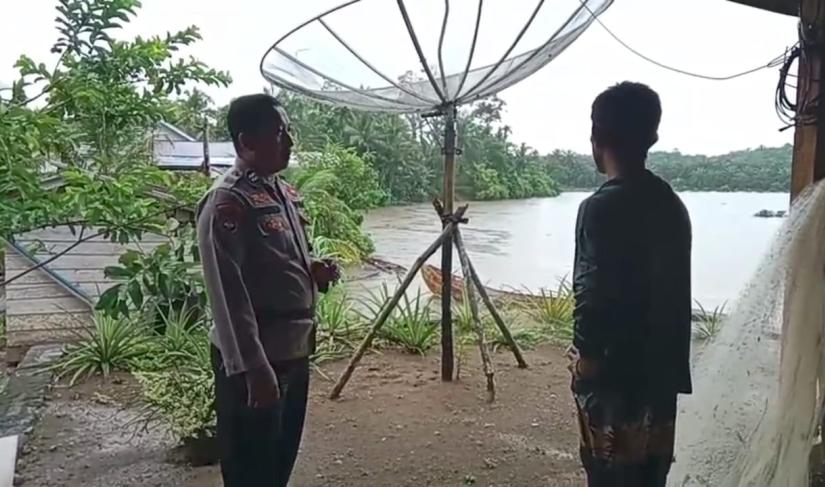 Bhabinkamtibmas Aiptu Budiyono dari Polsek Teras Terunjam memantau debit air Sungai Selagan sebagai bagian dari kesiapsiagaan banjir. (foto: Yusuf/Penarafflesia.com)