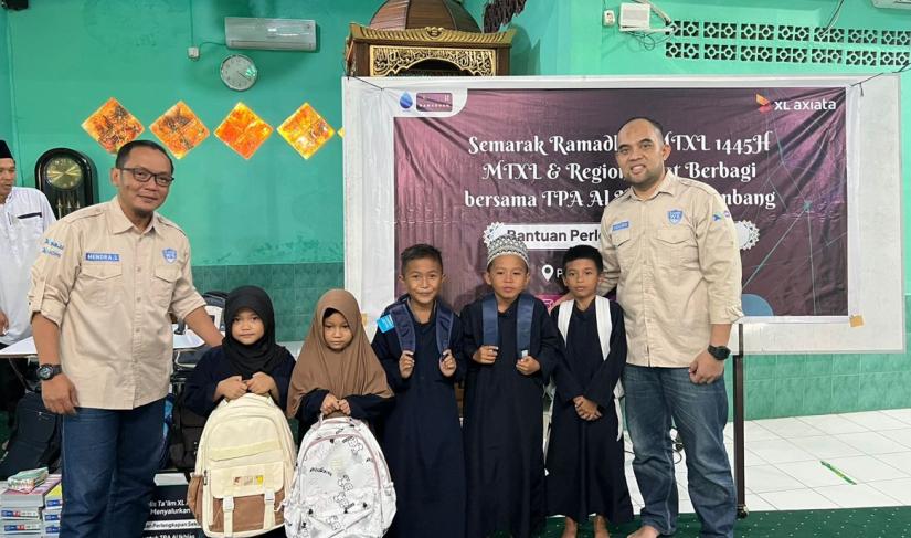 Territory Sales XL Axiata area Palembang, Yuswardi (paling kanan) dan Terrritory Sales XL Axiata area Banyu Asin, Hendra Salman (paling kiri) saat menyerahkan donasi melalui Program Semarak Ramadan 1445 H berupa Bantuan Perlengkapan Sekolah ke TPA Al Ikhlas Palembang, Selasa (2/4). 