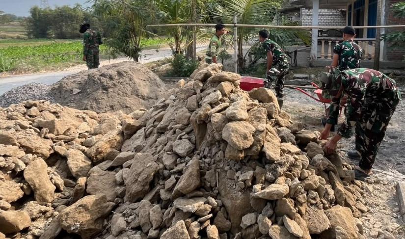 Selain memperbaiki bagian dinding, sejumlah anggota TNI bersama masyarakat juga bergotong royong menyelesaikan pekerjaan lain, mulai dari pengadukan material hingga pemasangan keramik lantai.