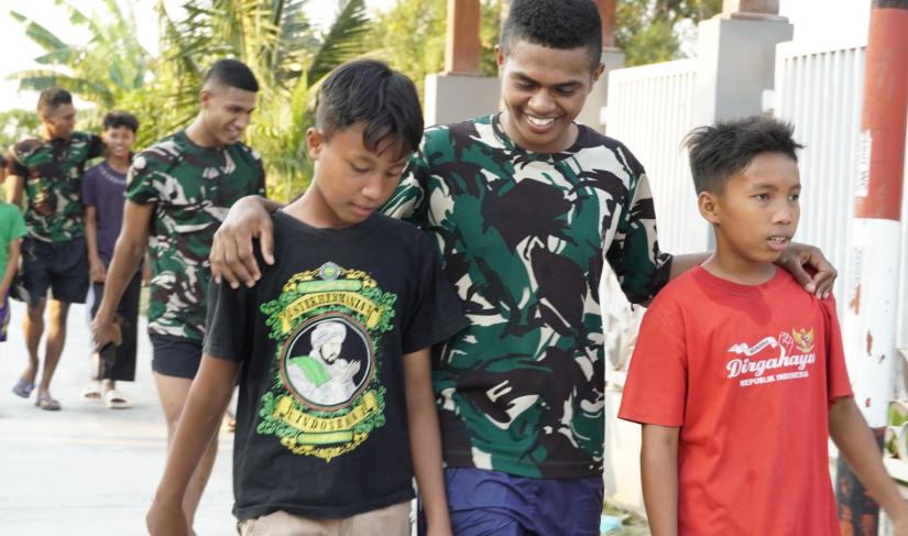 Kehangatan antara prajurit TNI dan masyarakat terlihat ketika sejumlah anggota Satgas berjalan berdampingan dengan anak-anak desa. Suasana santai dan penuh canda menjadi gambaran kedekatan yang terjalin selama pelaksanaan program TMMD.