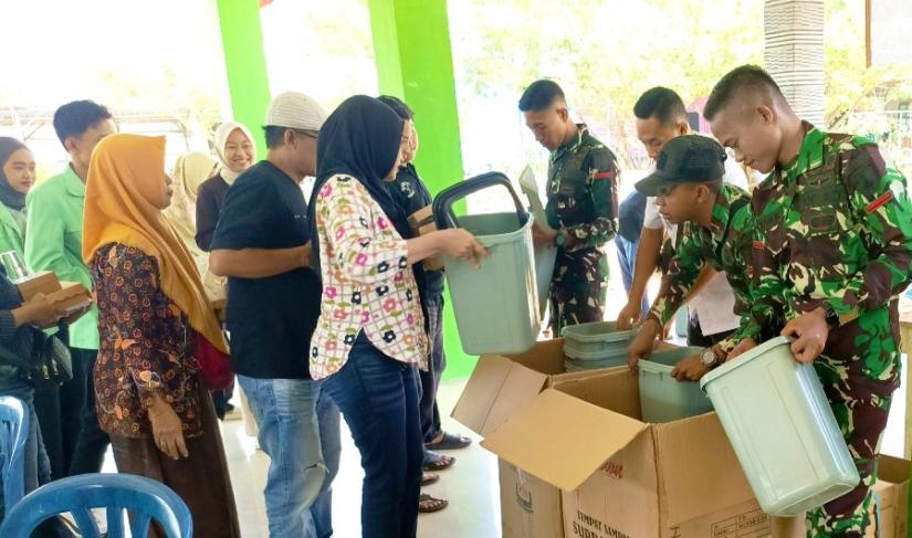 Personel Satgas TMMD ke-129 Kodim 0813/Bojonegoro membagikan tempat sampah kepada warga sebagai bagian dari edukasi menjaga kebersihan lingkungan di Desa Kesongo, Kecamatan Kedungadem, Kabupaten Bojonegoro, Kamis (6/8/2026). Foto: Deni Ari Pandi/Sumber TMMD Bojonegoro.