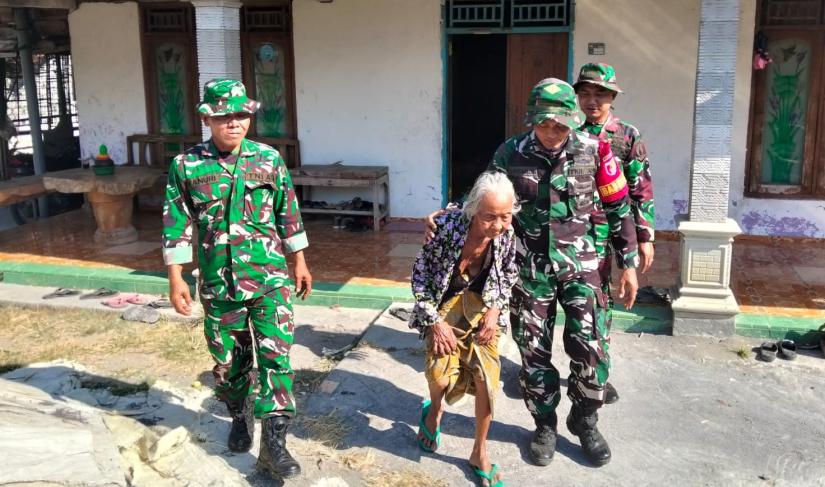 Dampingi Mbah Kasidah: Babinsa Desa Kesongo Serka Lasmidi mendampingi Mbah Kasidah saat melihat proses rehabilitasi rumah milik putranya, Ladi, melalui program Rutilahu TMMD ke-129 Kodim 0813 Bojonegoro di Dusun Pareng, Desa Kesongo, Kecamatan Kedungadem, Jumat (7/8/2026).