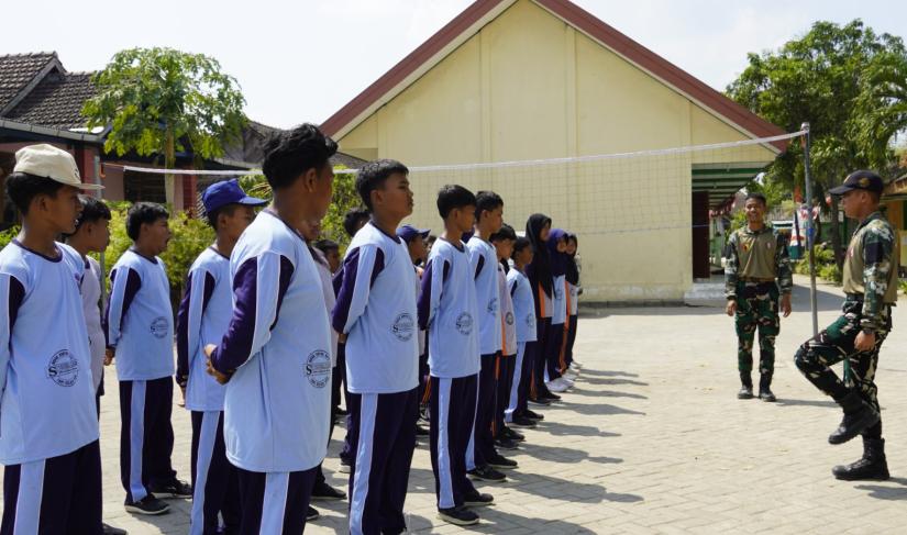Anggota Satgas TMMD ke-129 Kodim 0813/Bojonegoro melatih Peraturan Baris Berbaris (PBB) kepada siswa SMP Negeri Satu Atap Kesongo, Desa Kesongo, Kecamatan Kedungadem, Kabupaten Bojonegoro.