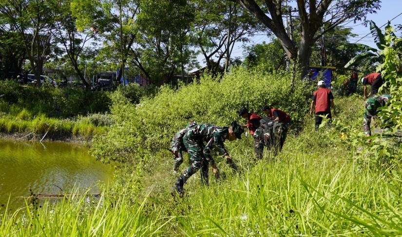 Selain mengerjakan pembangunan fisik, personel Satgas TMMD bersama mahasiswa Kuliah Kerja Nyata Tematik Kolaboratif (KKNTK) Universitas Bojonegoro (Unigoro) menggelar aksi bersih-bersih di kawasan Embung Bekatul, Kamis (16/7/2026).