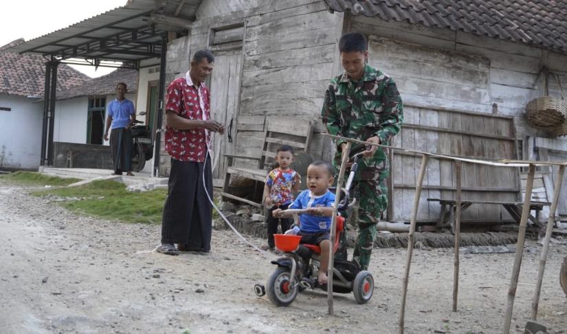 Di sela waktu istirahat usai bekerja, sejumlah personel Satgas TMMD terlihat meluangkan waktu bermain bersama anak-anak Desa Kesongo. Salah satu momen yang paling menyita perhatian adalah ketika seorang prajurit dengan sabar mendampingi balita yang sedang belajar mengayuh sepeda roda tiga di halaman rumah warga.