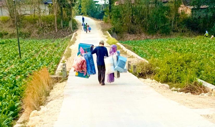  Pedagang keliling melintas di jalan beton hasil pembangunan program TMMD ke-129 di Dusun Mundu, Desa Kesongo, Kecamatan Kedungadem, Kabupaten Bojonegoro, Senin (10/8/2026). Foto: Deni Flamboyan/Sumber TMMD Bojonegoro