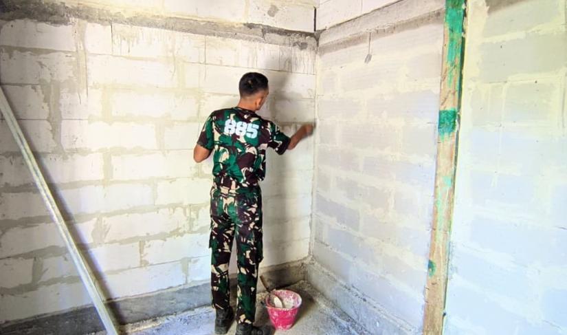 Dinding bata ringan yang sebelumnya tampak sederhana kini mulai terlihat lebih rapi setelah mendapat sentuhan tangan para prajurit Satgas TNI Manunggal Membangun Desa (TMMD) ke-129 Kodim 0813 Bojonegoro.