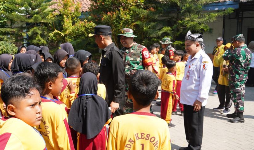 Di sela-sela rangkaian kegiatan TMMD, prajurit TNI menyempatkan berinteraksi dengan siswa-siswi SDN Kesongo I, Desa Kesongo, Kecamatan Kedungadem, Rabu (15/7/2026).