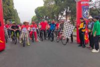 Wabup BU Arie Septia Adinata SE M.Ap.mengangkat bendera star tanda sepeda santai akan di mulai 