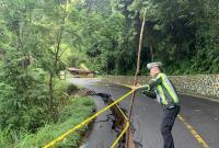 Polisi pasang garis pengaman di lintas Liku Sembilan yang longsor.