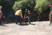 Babinsa Desa Kesongo Serka Lasmidi bersama petugas DLH Kabupaten Bojonegoro menyiapkan lubang tanam pohon di kawasan tanggul sungai Desa Kesongo dalam rangkaian TMMD ke-129.