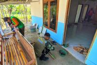 Gotong Royong Renovasi RTLH: Anggota Satgas TMMD ke-129 Kodim 0813 Bojonegoro bersama warga bergotong royong mengerjakan renovasi rumah Jasmiati di RT 009/RW 003, Desa Kesongo, Kecamatan Kedungadem, Jumat (7/8/2026). Renovasi dilakukan untuk menghadirkan hunian yang lebih aman dan nyaman bagi keluarga penerima manfaat.