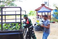 Babinsa Desa Kesongo, Serka Lasmidi, membantu menyalurkan 750 bibit sayuran dari DKPP Kabupaten Bojonegoro kepada warga dalam rangka penguatan ketahanan pangan melalui program TMMD ke-129 Kodim 0813/Bojonegoro, Desa Kesongo, Kecamatan Kedungadem, Kamis (6/8/2026). Foto: Deni Ari Pandi/Sumber TMMD Bojonegoro.