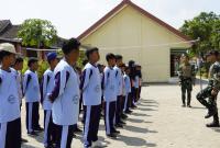 Anggota Satgas TMMD ke-129 Kodim 0813/Bojonegoro melatih Peraturan Baris Berbaris (PBB) kepada siswa SMP Negeri Satu Atap Kesongo, Desa Kesongo, Kecamatan Kedungadem, Kabupaten Bojonegoro.